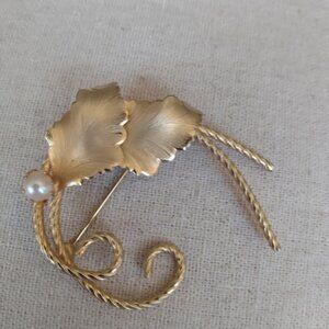 Vintage gold tone leaf brooch with a faux pearl.